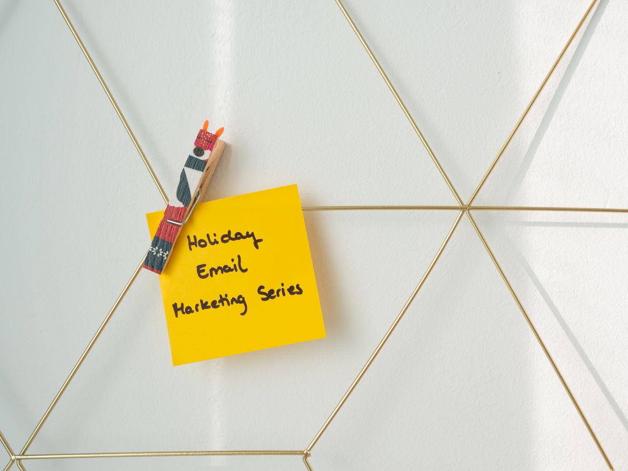 services-04 Bright yellow sticky note with holiday email marketing message clipped to a wireframe wall.