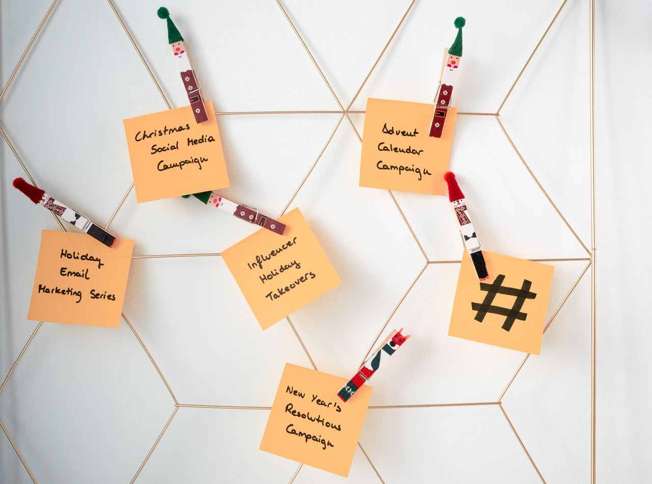 team-01 Sticky notes with holiday marketing ideas clipped to a wall grid.